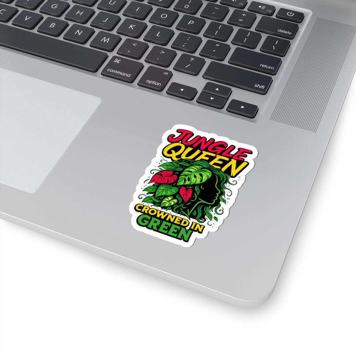 Laptop with a 'Jungle Queen Crowned in Green' sticker on the palm rest area.