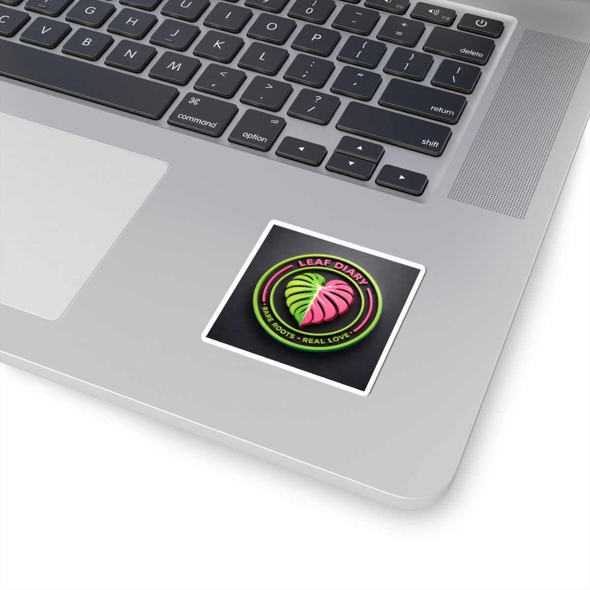 Laptop with a sticker featuring a leaf design and text on the palm rest area.